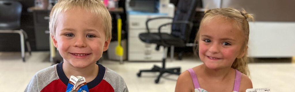Un niño y una niña sonriendo en una clase