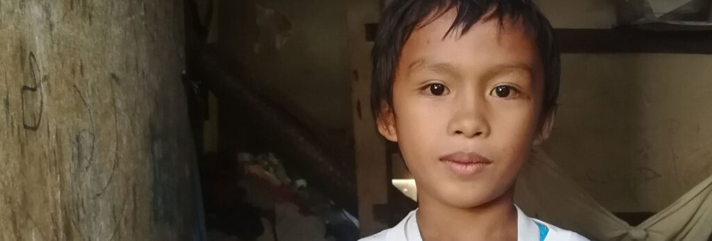 Un niño de pie en una habitación poco iluminada