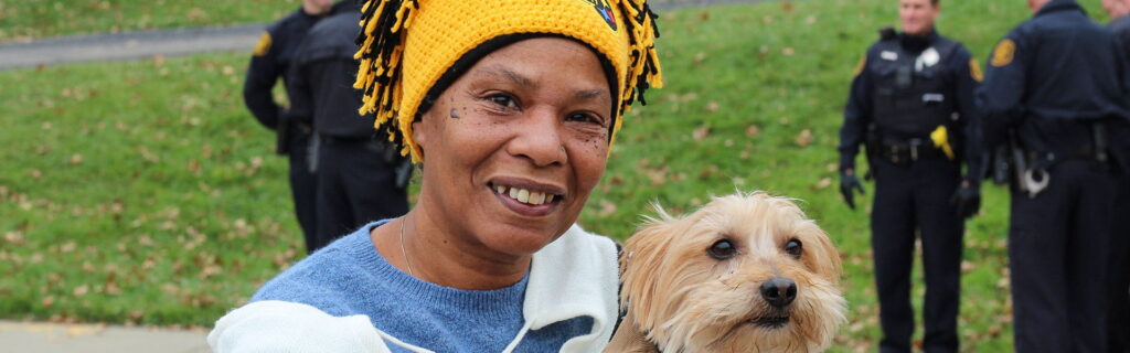 Una mujer sonriendo con un perro