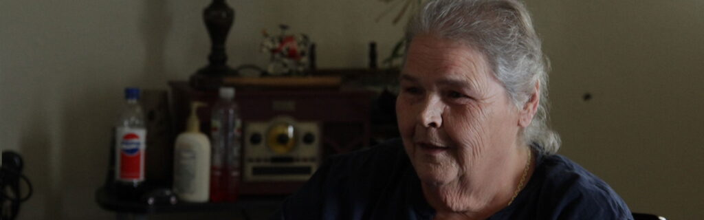 Una mujer hablando en una habitación oscura