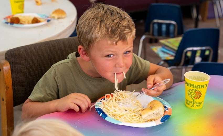 un niño comiendo en una mesa
