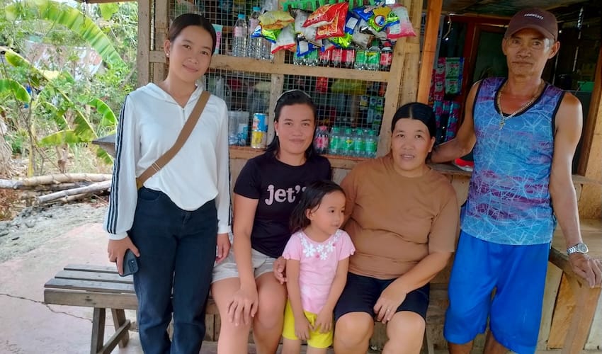 A family sitting on a bench on a patio