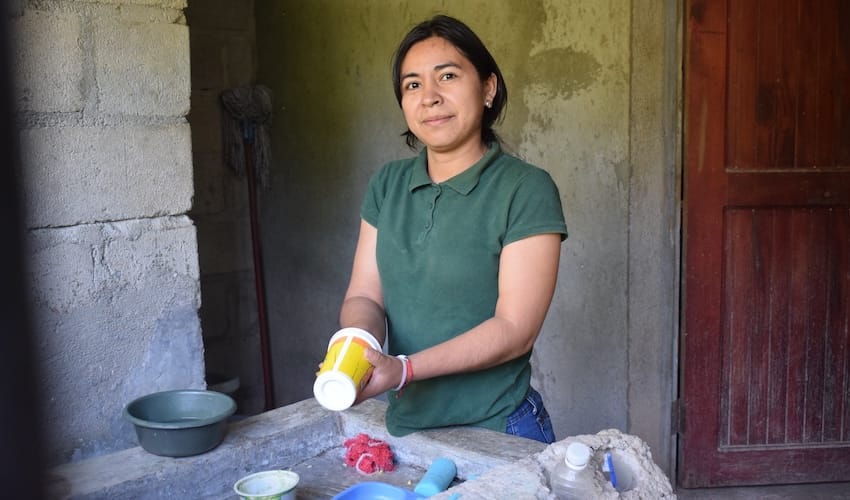 A woman cleaning dishes in a kitchen