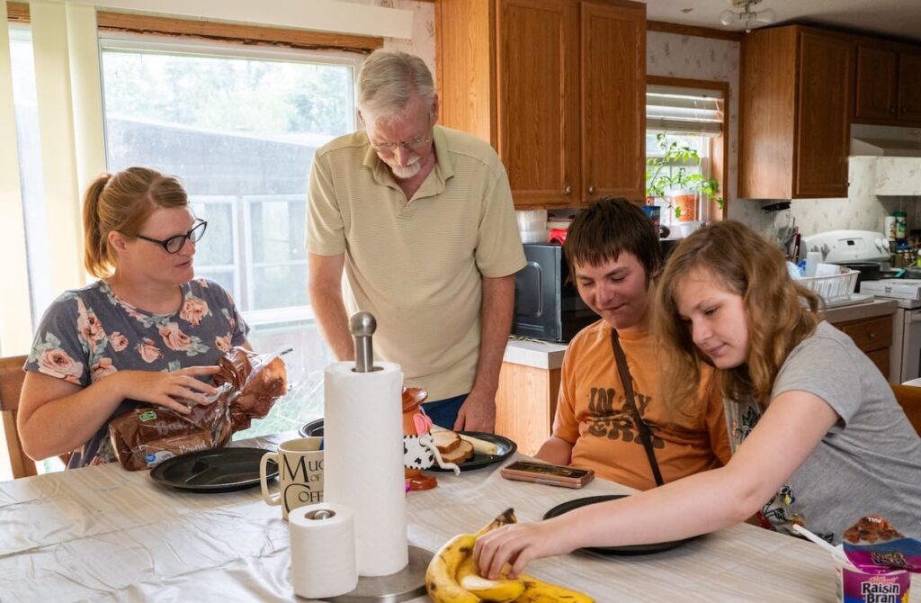 Una familia reunida alrededor de una mesa comiendo