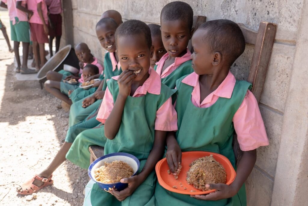 Children eating outdoors in Kenya.