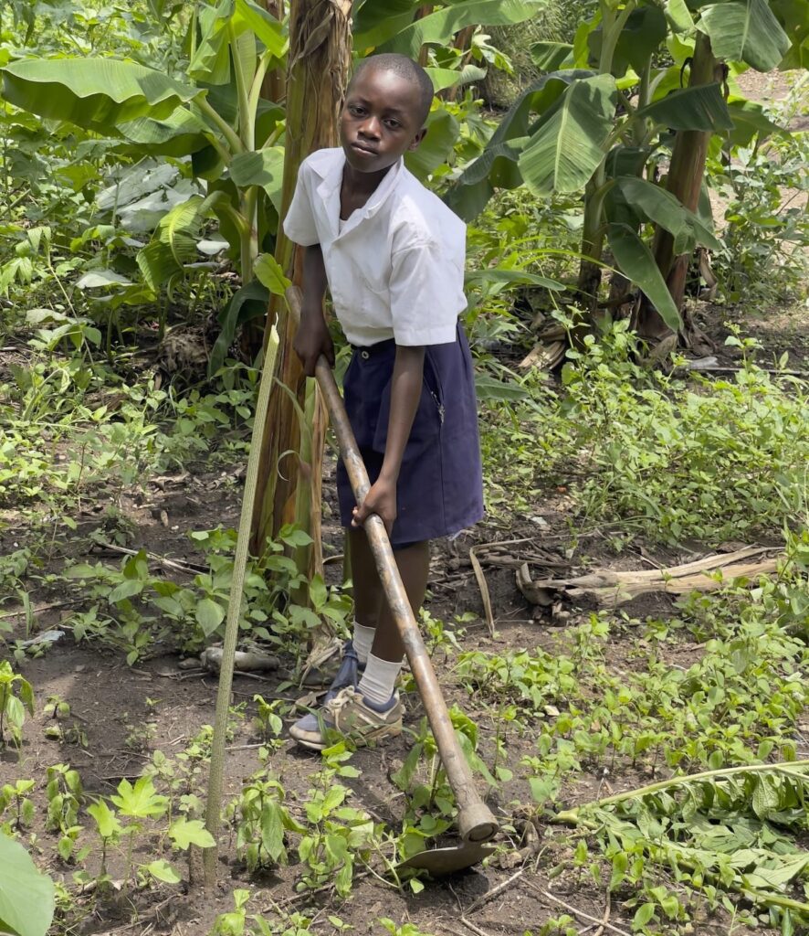 Un niño cuidando un huerto en Tanzania.