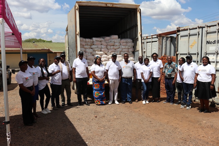 A group of people in front of a truck of supplies in Africa.