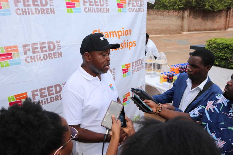 A man being interviewed outdoors at an event.