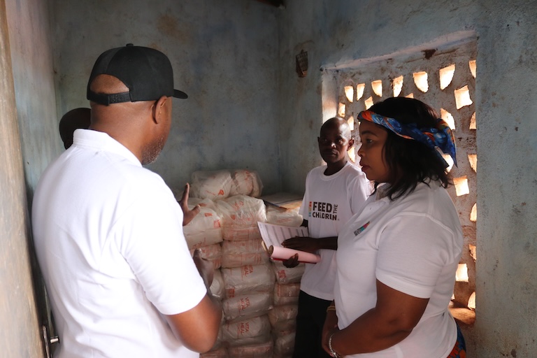 A group of people indoors with food supplies.