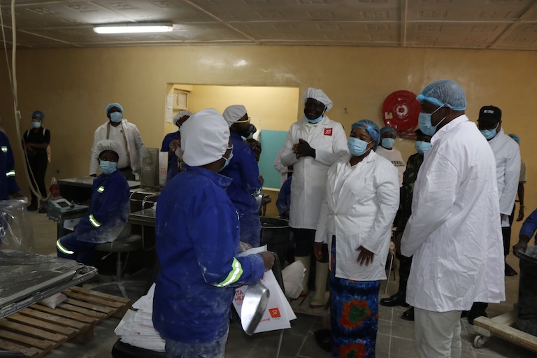 A group of people wearing masks in a building.