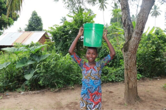 Beatrice balencing a bucket on the head