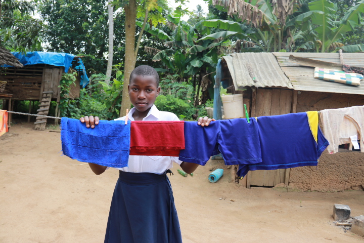 Beatrice standing behind a clothes line drying clothes