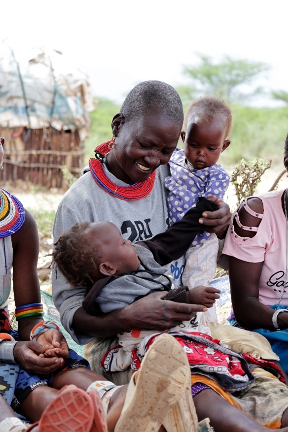A woman with her two babies in a care group.