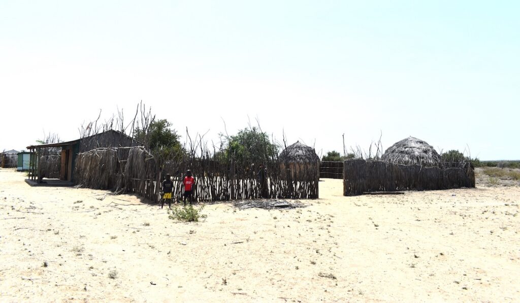 Everline's children standing by the fencing of the village.